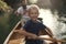 Young boy paddling canoe on the lake with his dad