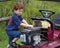 Young boy playing with broken lawnmower