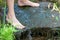 Young boy playing with clear water at a little creek using his hands and the clear water spring cooling his feet