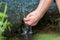 Young boy playing with clear water at a little creek using his hands and the water spring cooling his hands plus refreshing