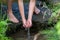 Young boy playing with clear water at a little creek using his hands and the water spring cooling his hands and refreshing