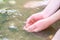 Young boy playing with clear water at a little creek using his hands and the water spring cooling his hands and refreshing