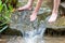 Young boy playing with clear water at a little creek using his hands and the water spring cooling his hands and refreshing