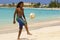 Young boy playing football on the beach in Barbados, Caribbean