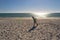 Young boy playing frisbee on beach. Child plays frisbee on the sand on beach near sea. Beach games and active toddler