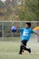 Young boy playing goalie with a big kick