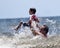 Young Boy Playing with Granddad in Big Crashing Wave