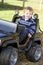 Young boy playing outdoors in toy truck smiling