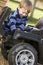 Young boy playing outdoors with toy truck smiling