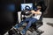 Young boy playing racing game on 2DOF motion simulator with virtual reality glasses