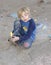 Young boy playing with sidewalk chalk