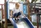 Young boy playing slide in playground