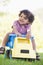 Young boy playing on toy dump truck outdoors