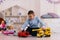 young boy playing toy trucks sitting on the floor in the nursery
