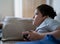 Young boy playing video games online, Candid shot Happy mixed race child lying on sofa holding game console. Portrait  kid face