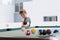 Young boy plays pool billiard, aiming the ball, at terrace, outdoor.
