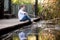 A young boy pretending to fish with a stick in a lake