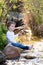 A young boy pretending to fish with a stick in a lake