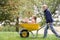 Young boy pushing girl in wheelbarrow