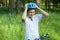Young boy in puts on helmet in park. Smiling cute boy on bicycle in the forest. Active fun healthy outdoor sport for children.
