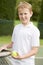 Young boy with racket on tennis court smiling