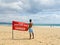 Young boy with a red flag in the beach