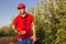 Young boy in red shirt and cap picking apples listening to music with red headphones