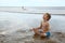 Young boy relaxing in lotus yoga pose on beach