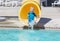 Young boy riding down a yellow water slide