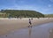 A Young Boy running down the Beach at Beadnell Bay in Northumberland, England with a Hoodie on.