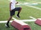 Young boy running over red barriers during football summer camp