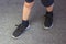 Young boy`s legs in textile fashion black sneakers. Children`s trendy casual outfit and street fashion. Top view, Close up