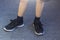 Young boy`s legs in textile fashion black sneakers. Children`s trendy casual outfit and street fashion. Top view, Close up