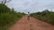 Young boy seen standing in path of dirt road