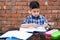 Young boy sharpening the pencil in classroom while attending class in primary School