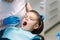 Young boy sitting on the dental chair at the office. Children`s dentist examination baby teeth
