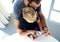 Young boy sitting with father and touching screen of pc tablet in sunny modern loft. Horizontal, blurred background. Top view.