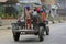 Young boy sitting standing on a converted rotary hoe used as Nepali styled mini tractor