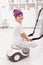 Young boy sitting on vacuum cleaner