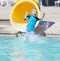 Young boy sliding out of a yellow water slide