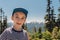 Young boy smiling with the Olympic mountains behind, on Hurricane Hill in Olympic National Park