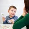 Young boy in speech therapy office. Preschooler exercising correct pronunciation with speech therapist. Child Occupational Therapy