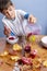 Young boy squeezing and pouring pomegranate juice, making a mess. Face and clothes dirty with red spots.