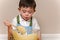 Young boy stirring cake mix in a glass bowl