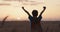 Young boy with a superhero cape stand in a golden wheat field during sunset