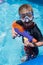 Young boy in swim mask holding water gun in swimming pool