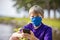Young boy texting while wearing a face mask during coronavirus pandemic