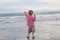 Young Boy Throwing Rock into Ocean Waves