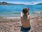 Young boy throwing stones in sea water. Desert beach Hertseg Novi. Kotor gulf, Montenegro