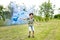 Young boy trailing a blue smoke flare in a park